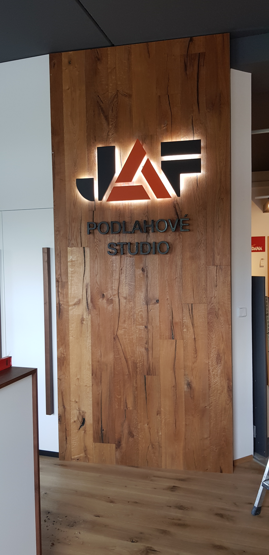 Dřevěný obklad s podsvíceným 3D logem